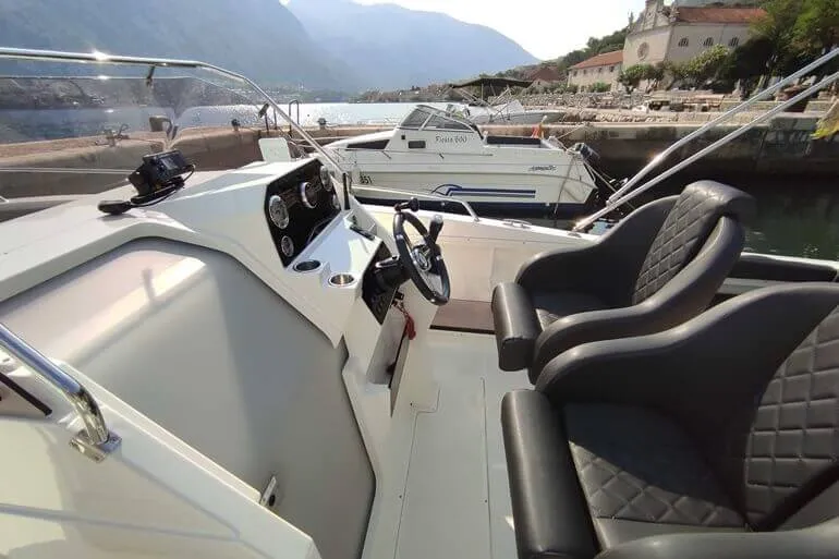 Pływacy skaczą z wynajętej łodzi motorowej do czystej wody Adriatyku