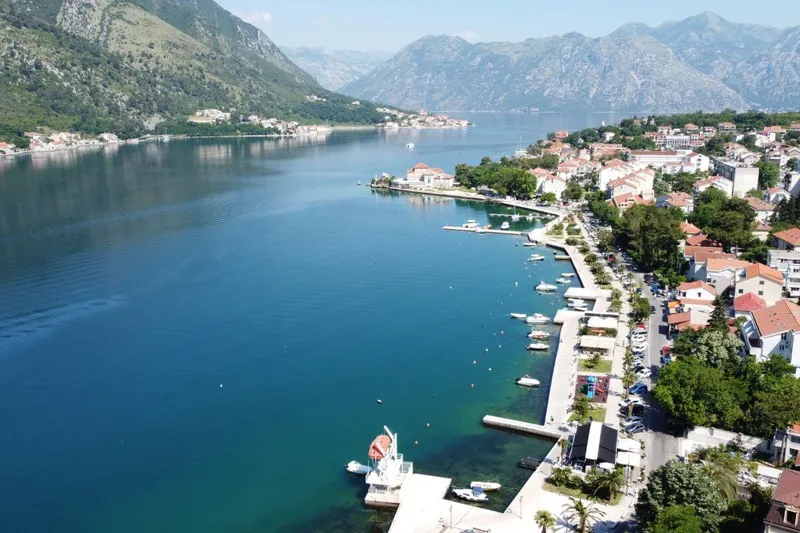 Private speedboat departing Kotor with fortress walls towering above