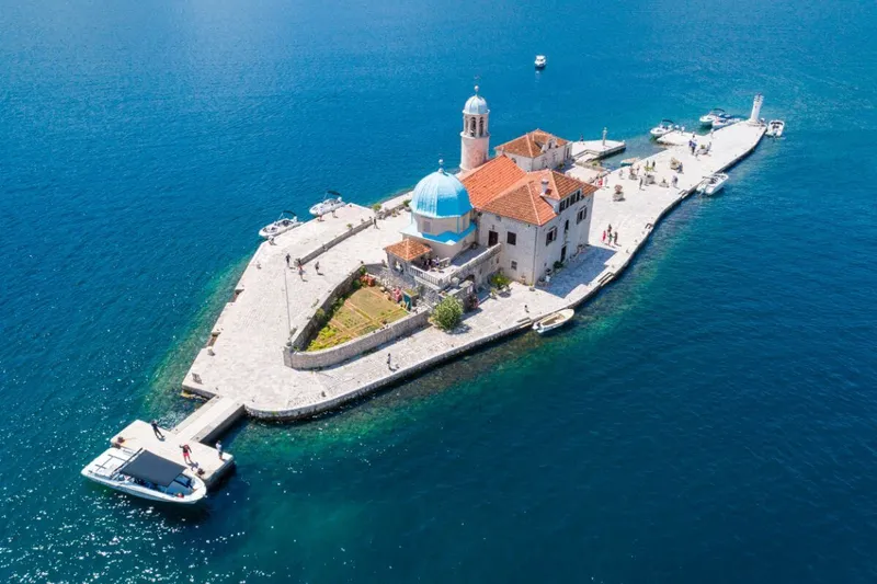 Kotor Körfezi'nde kristal berraklığında bir koyda yüzen misafirler Kotor Körfezi'nde kristal berraklığında bir koyda yüzen misafirler